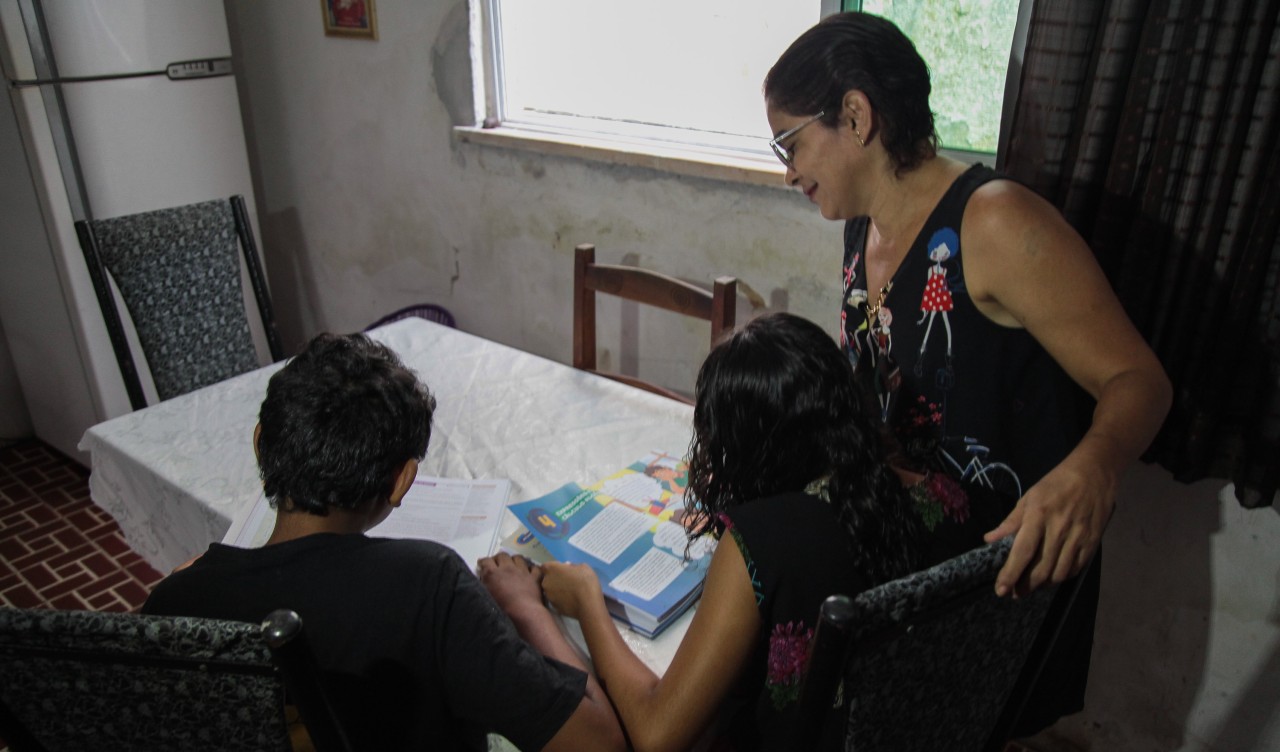 Virgínia Freitas observa os adolescentes que acolheu (que estão de costas, lendo um livro)